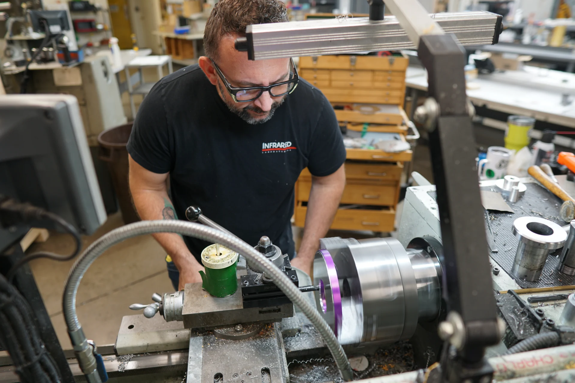 IRLabs technician operating a manual lathe in the precision manufacturing facility. IRLabs technician operating a manual lathe in the precision manufacturing facility.